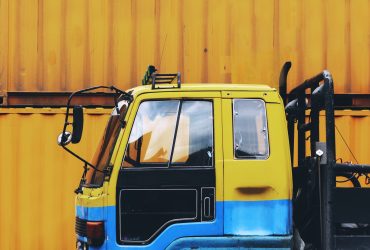 Yellow truck parked near a yellow container box